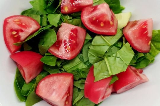Cut pieces of tomato and spinach. 