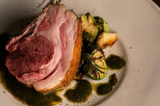 Raw lamb leg on a garnished plate